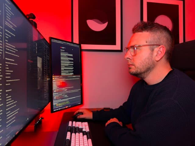 Shane at his desk, working across two screens